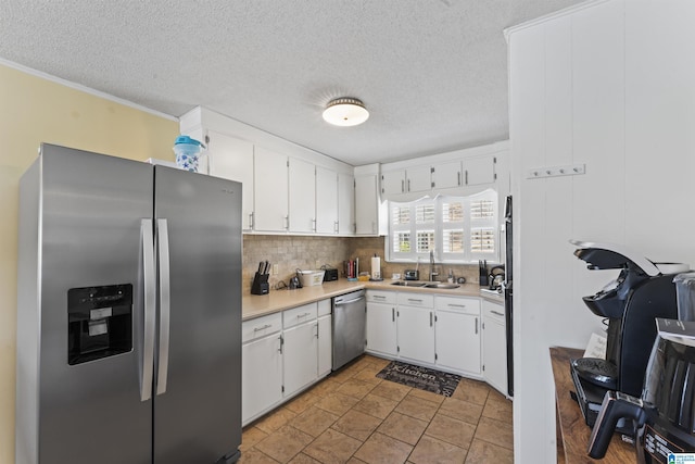 kitchen featuring stainless steel appliances, white cabinetry, sink, and tasteful backsplash