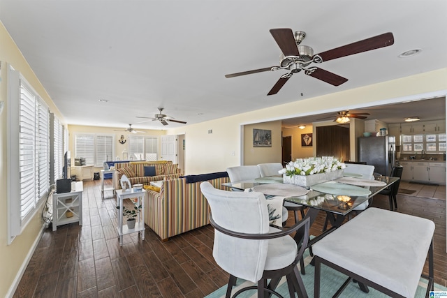 dining room with sink, dark wood-type flooring, and a wealth of natural light