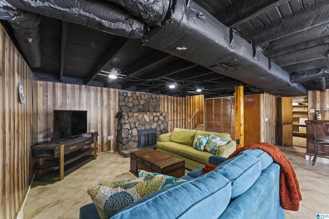 living room with a stone fireplace and wooden walls