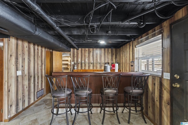 bar featuring tile patterned flooring and wood walls