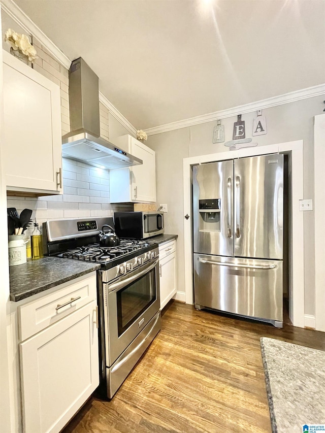 kitchen with white cabinetry, appliances with stainless steel finishes, and wall chimney range hood