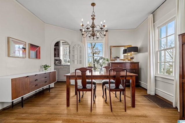 dining room featuring crown molding, a chandelier, and light hardwood / wood-style floors