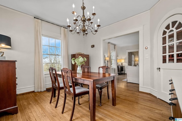 dining space with a notable chandelier, light hardwood / wood-style flooring, and ornamental molding