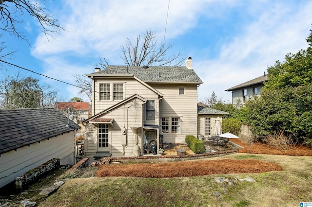 rear view of house featuring a lawn