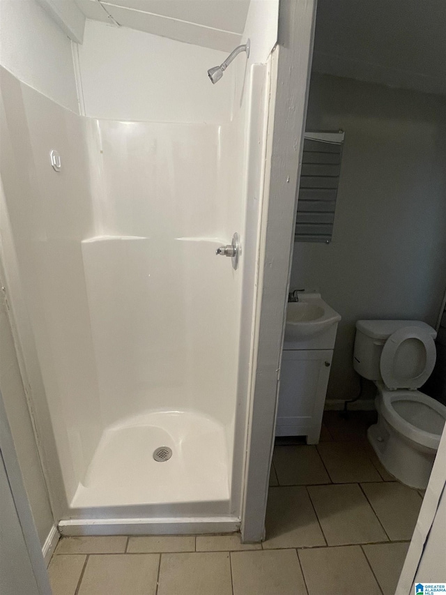 full bathroom featuring vanity, tile patterned flooring, a shower stall, and toilet