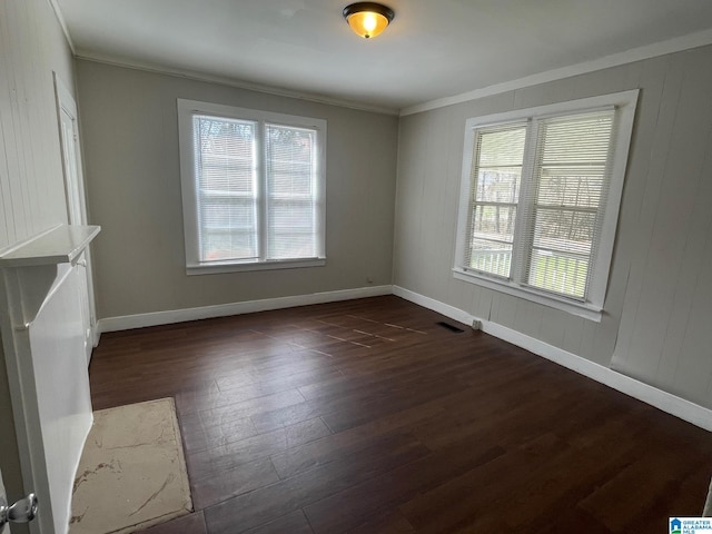 unfurnished living room with visible vents, baseboards, dark wood finished floors, and ornamental molding