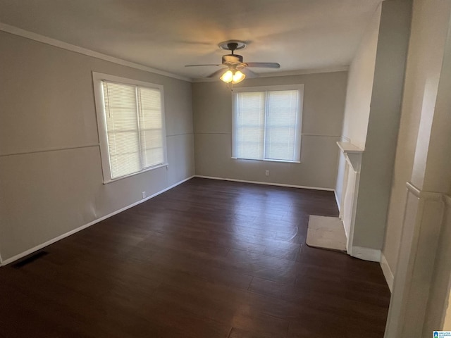 unfurnished living room featuring ceiling fan, a fireplace, baseboards, ornamental molding, and dark wood-style floors