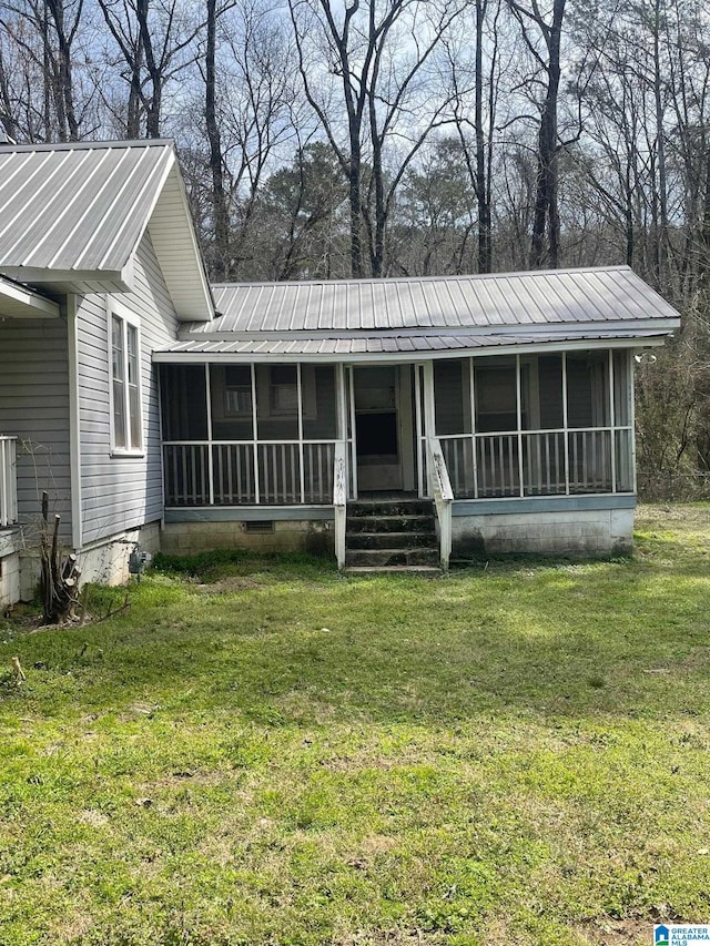 view of front facade featuring crawl space, a sunroom, metal roof, and a front lawn