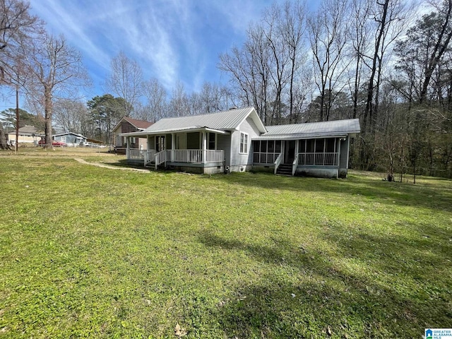 view of front of property with a porch, a front yard, a sunroom, and metal roof