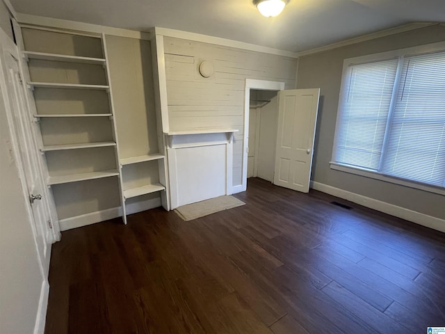 unfurnished bedroom with baseboards, visible vents, dark wood finished floors, and ornamental molding