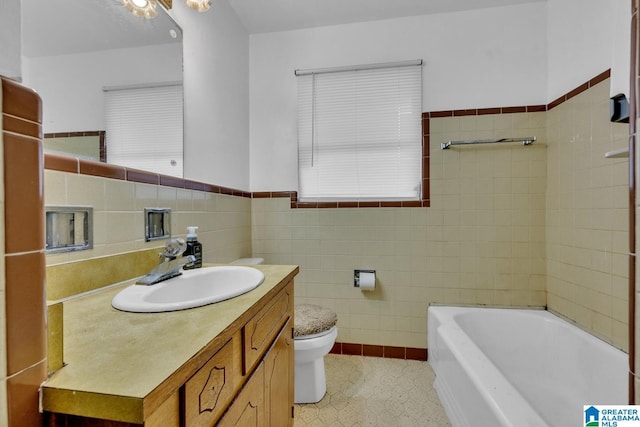 bathroom featuring vanity, toilet, tile walls, and a tub