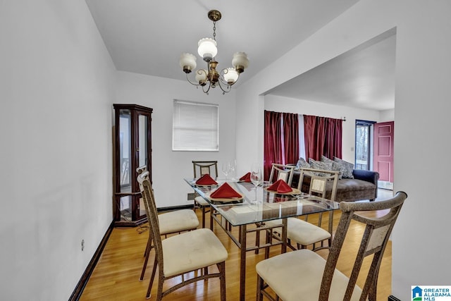 dining space featuring an inviting chandelier and light wood-type flooring