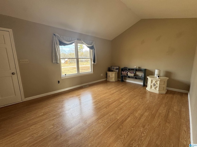 additional living space featuring lofted ceiling and light hardwood / wood-style floors