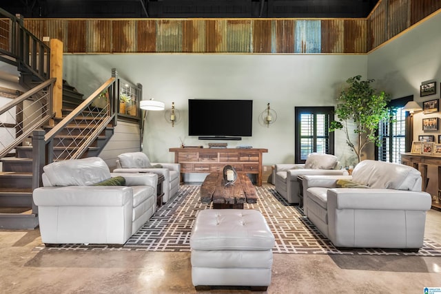 living room with a towering ceiling and concrete floors