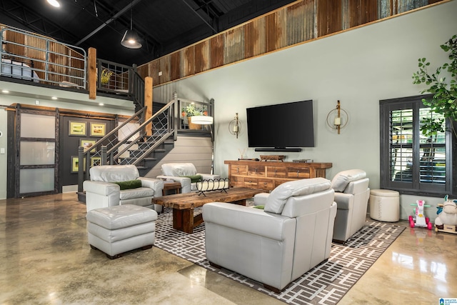 living room featuring a high ceiling and concrete floors