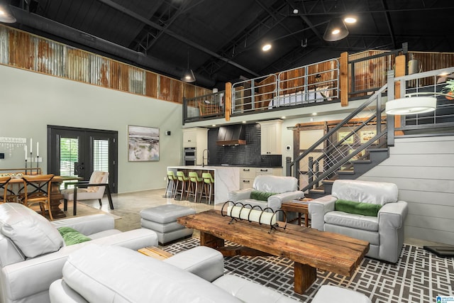 living room featuring sink, a towering ceiling, and french doors