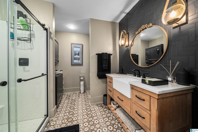 bathroom with a shower with door, vanity, and decorative backsplash