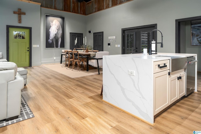 kitchen featuring white cabinetry, sink, a center island with sink, and light hardwood / wood-style flooring