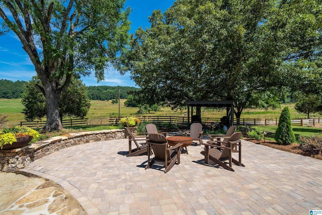 view of patio featuring a rural view and an outdoor fire pit