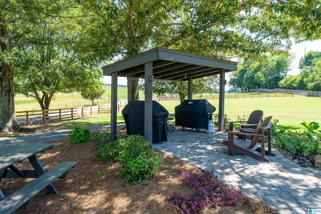 view of patio / terrace featuring area for grilling, a gazebo, and a rural view