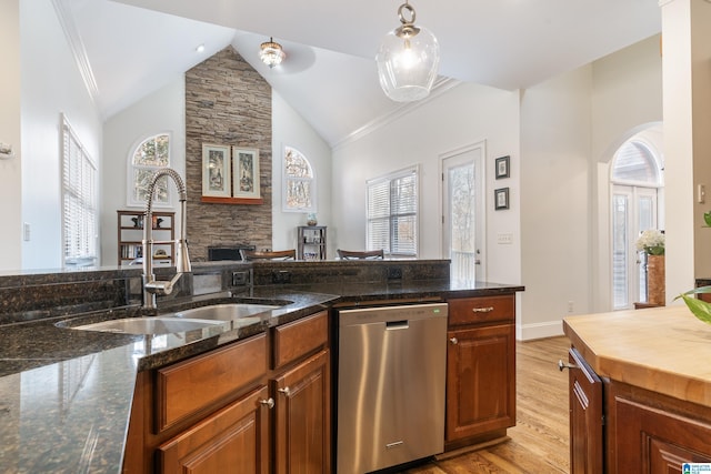 kitchen featuring pendant lighting, sink, dark stone countertops, light hardwood / wood-style floors, and stainless steel dishwasher