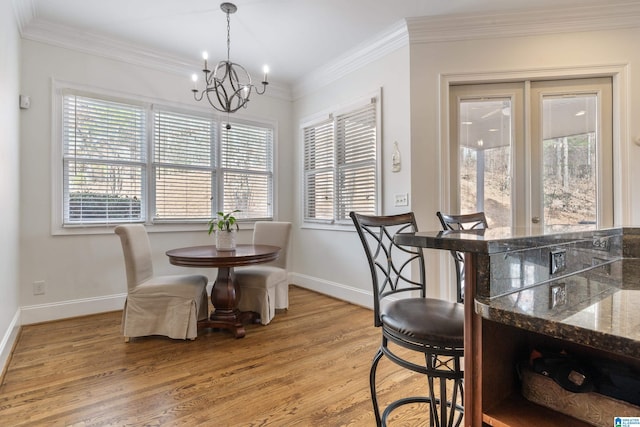 dining room featuring ornamental molding, a chandelier, and light hardwood / wood-style floors