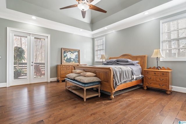 bedroom featuring hardwood / wood-style flooring, a raised ceiling, and access to outside