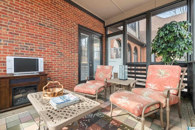 sunroom featuring a healthy amount of sunlight and a fireplace