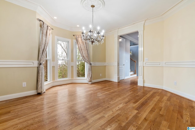 unfurnished dining area featuring crown molding, an inviting chandelier, and light wood-type flooring