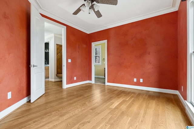 empty room with crown molding, ceiling fan, and light wood-type flooring