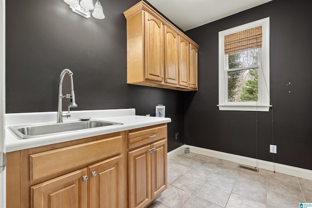 washroom with washer hookup, sink, light tile patterned floors, and cabinets