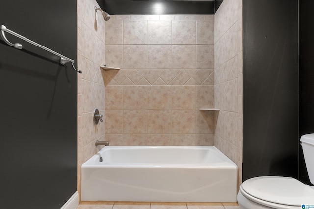 bathroom featuring tile patterned flooring, toilet, and tiled shower / bath