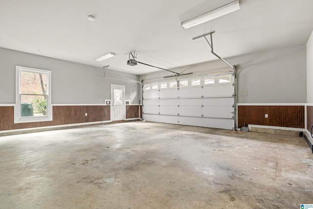 garage with a garage door opener and wooden walls