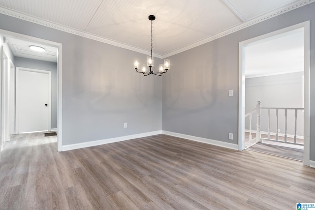 empty room with crown molding, a notable chandelier, and light hardwood / wood-style floors