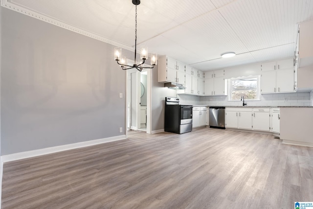 kitchen featuring white cabinetry, sink, decorative light fixtures, and appliances with stainless steel finishes