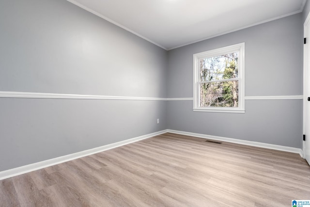 unfurnished room with ornamental molding and light hardwood / wood-style floors