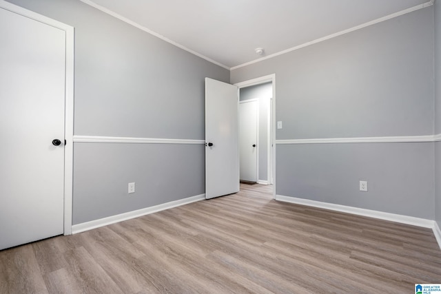 unfurnished bedroom with ornamental molding and light wood-type flooring