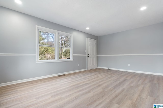 empty room with light hardwood / wood-style flooring