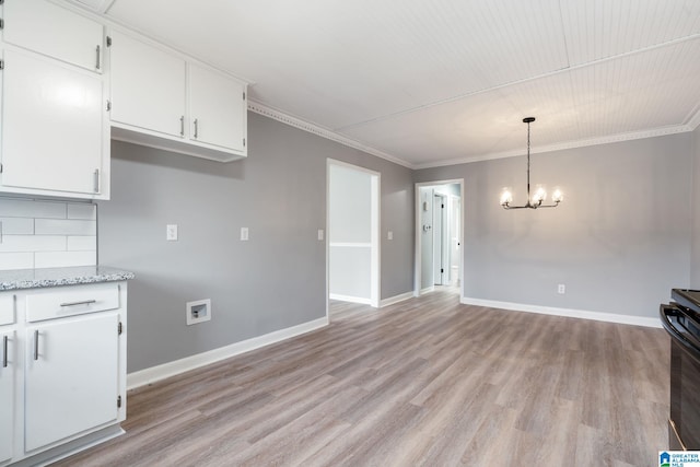 kitchen featuring crown molding, hanging light fixtures, and white cabinets