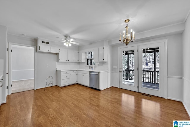 kitchen with white cabinetry, stainless steel dishwasher, hanging light fixtures, and light wood-type flooring