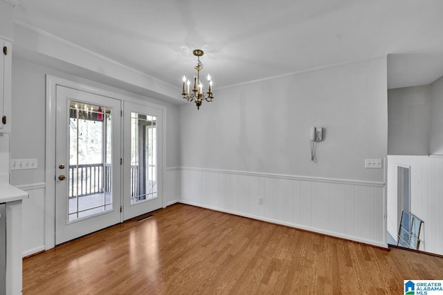 interior space featuring crown molding, an inviting chandelier, and light wood-type flooring