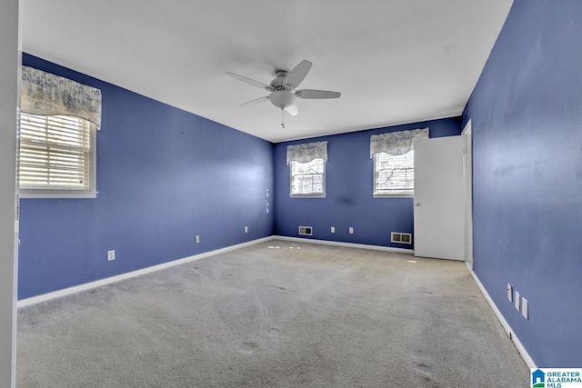 empty room featuring ceiling fan and light carpet