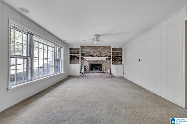 unfurnished living room with a fireplace, ceiling fan, and carpet