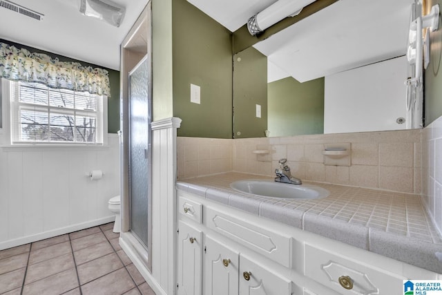 bathroom featuring walk in shower, tile patterned floors, toilet, and vanity