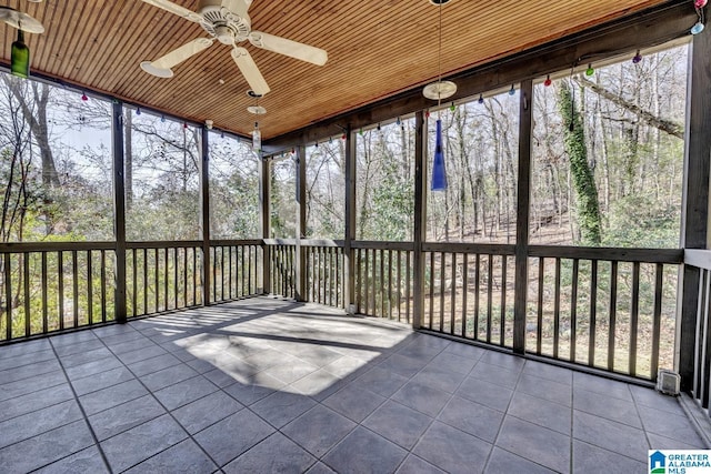 unfurnished sunroom with wood ceiling and ceiling fan