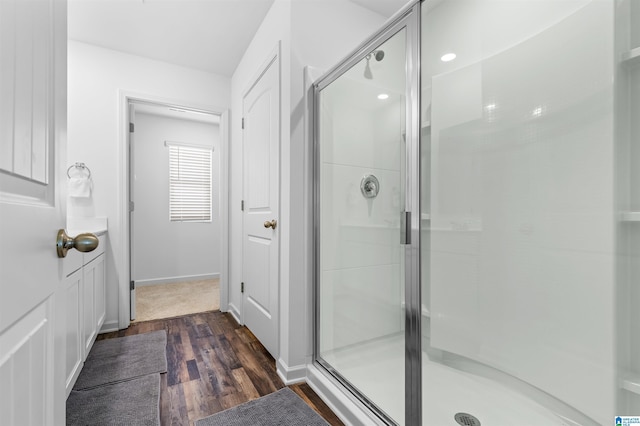 bathroom with hardwood / wood-style flooring and an enclosed shower