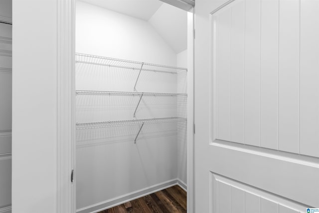 walk in closet featuring dark hardwood / wood-style flooring and lofted ceiling