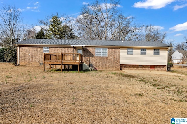 back of property featuring a wooden deck and a lawn