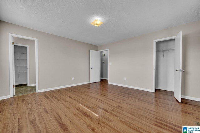 unfurnished bedroom featuring a closet, light hardwood / wood-style floors, and a textured ceiling