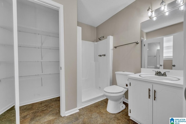 bathroom featuring vanity, toilet, and a shower